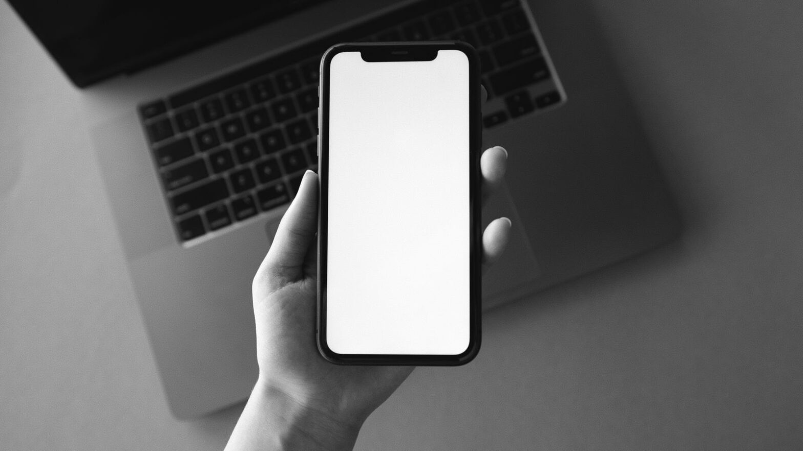 Людина тримає iPhone зі США без фізичного SIM-лотка