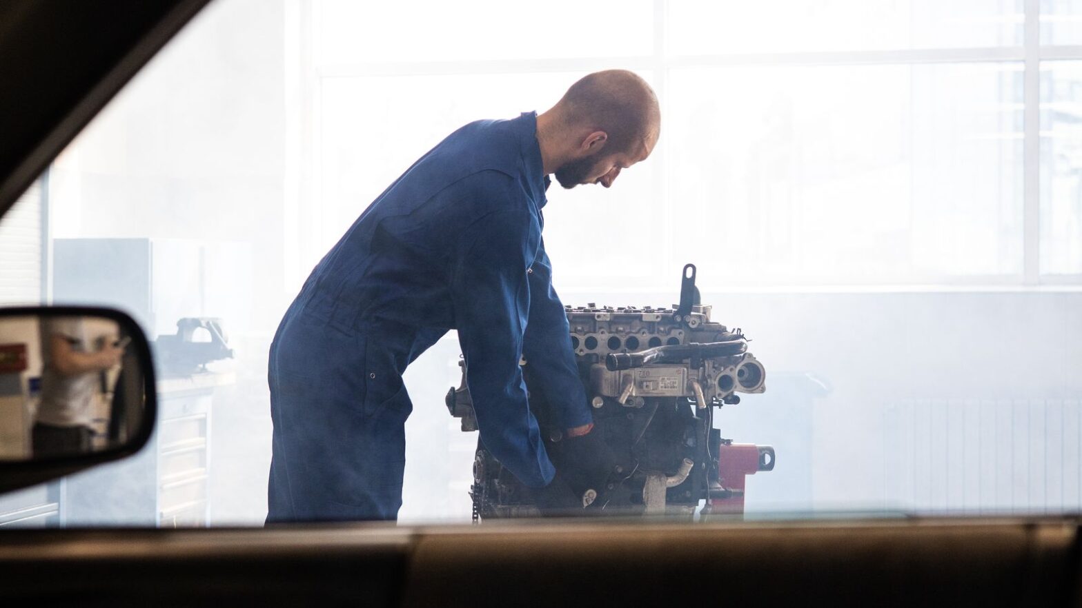 Механік перевіряє вживаний автомобільний двигун перед доставкою з Європи